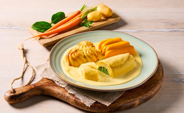 Püriertes Omelette in Soße mit Spinat-Käse Füllung in Käsesoße dazu Karotten-Steckrüben-Gemüse und Kartoffelrosetten