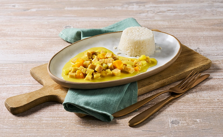 Weiches Hühnerragout in fruchtiger Currysoße dazu Reis in Soße