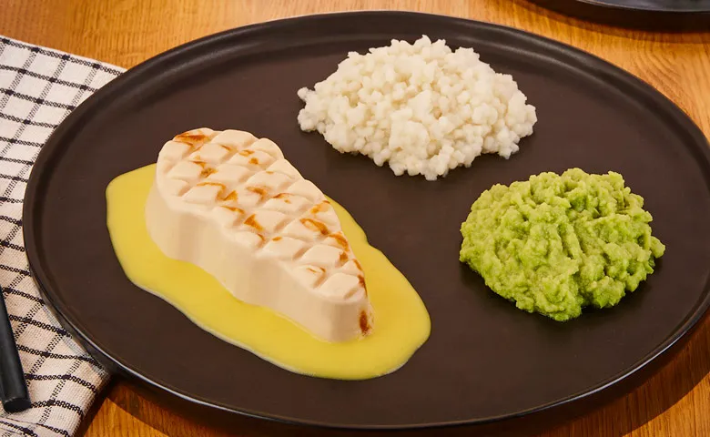 Zerkleinertes Hähnchensteak in Currysoße dazu Erbsen und feine Nudeln