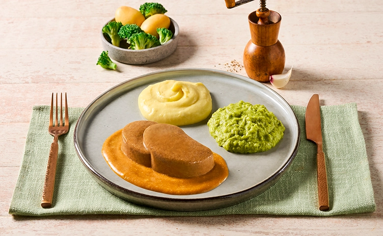 Zerkleinerter Schweinebraten in Bratensoße dazu Brokkoli und Stampfkartoffeln