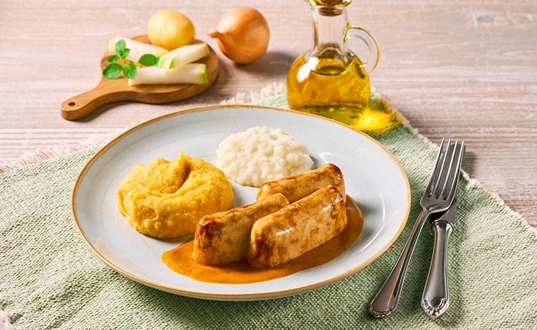 Zerkleinerte Bratwurst in Bratensoße mit Kohlrabi und Bratkartoffeln