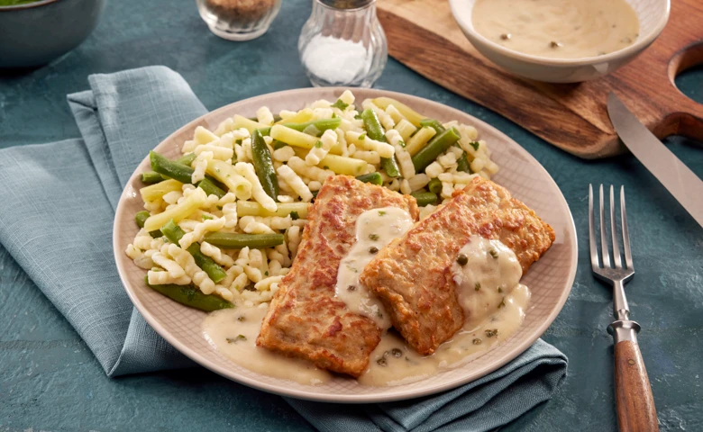 Zwei Schweinehacksteaks in Pfefferrahmsoße, dazu Bohnengemüse und Knöpflespätzle