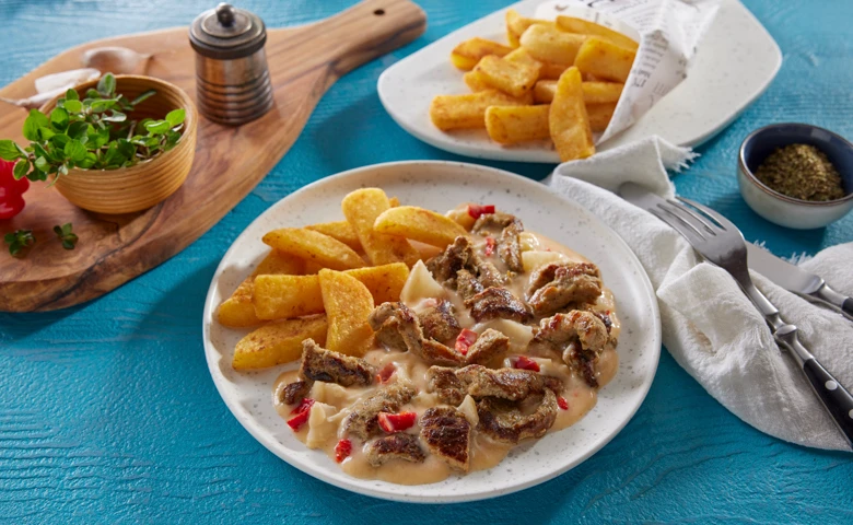 Gyros Auflauf typisch griechisch gewürztes Schweinegeschnetzeltes mit Sauerrahm und Käse überbacken, dazu Steakhouse frites