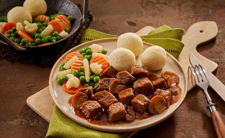 Zartes Rindergulasch vom Rind in Champignonsoße, dazu Gemüse "Leipziger Allerlei" und Kartoffelklöße