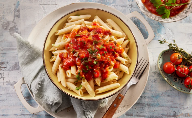Penne all'Arrabbiata in einer delikaten Tomatensoße mit Paprika, Zucchini und Zwiebeln