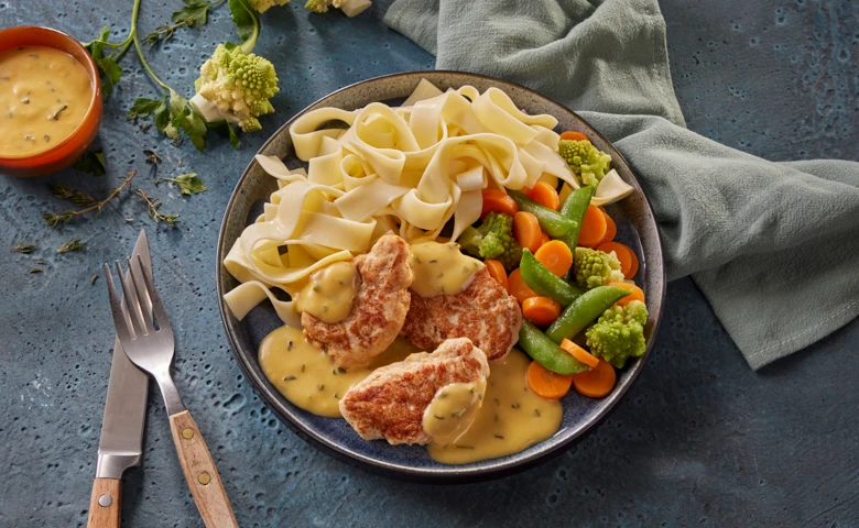 Putenmedaillons in Butter-Kräutersoße mit feinem Gartengemüse und Bandnudeln