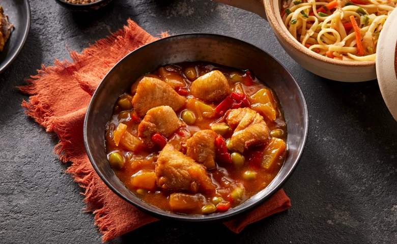 Hähnchen "süß-sauer" Hähnchenfiletstücke in süß-saurer Soße mit Paprika, Sojabohnen und Ananas, dazu Mie-Nudeln mit Gemüsestreifen