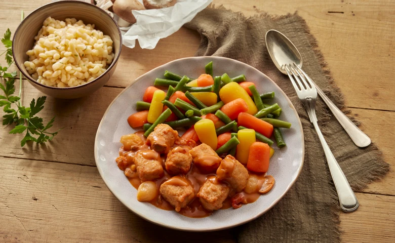 Veggie Gulasch "new classic" (auf Soja- und Weizenbasis) in cremiger Soße mit Champignons und Silberzwiebeln, dazu Knöpfe-Spätzle und buntes Gemüse